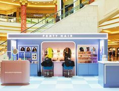 an empty beauty store with two chairs in front of it and stairs leading up to the second floor