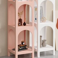 three shelves with books, vases and other items on them in the corner of a room