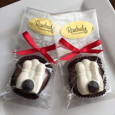 two chocolate cupcakes with white frosting and red ribbon