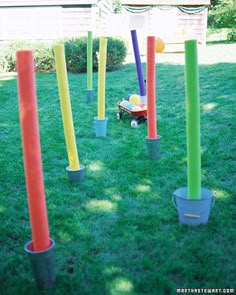 an assortment of colorful plastic poles in the grass