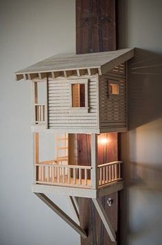 a doll house built into the side of a wooden treehouse with stairs and balconies