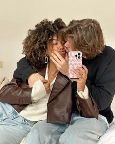 two people are sitting on a bed and one is kissing the other's face