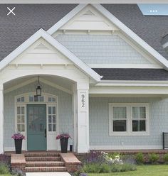 a house with flowers in front of it and the number one on the front door