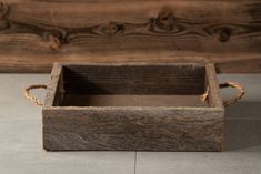 a wooden box sitting on top of a tile floor