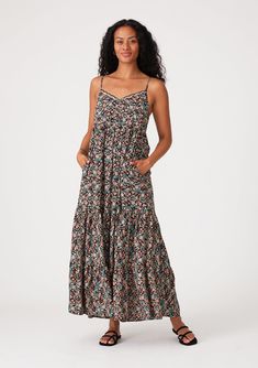 An ultra-flowy sleeveless summer maxi dress in a black and teal floral print. Floral print Relaxed, flowy fit Sleeveless Maxi length Tiered skirt V-neckline with scalloped edge Self-covered button front top Adjustable spaghetti straps Side pockets Flowy bohemian maxi dress A flowy silhouette adds an effortless touch to this bohemian chic maxi dress. Designed in a versatile black and teal floral print. The adjustable spaghetti straps allow for a customizable fit, while the scalloped edge trim add Black Tiered Maxi Sundress, Black Sleeveless Rayon Maxi Dress, Black Tiered Maxi Dress For Beach, Printed Rayon Sundress Maxi Dress, Casual Flowy Maxi Sundress, Printed Rayon Maxi Sundress, Flowy Spaghetti Strap Floral Maxi Dress, Flowy Maxi Dress With Spaghetti Straps And Floral Print, Flowy Floral Print Maxi Dress With Spaghetti Straps