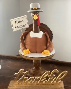 a cake shaped like a turkey holding a sign