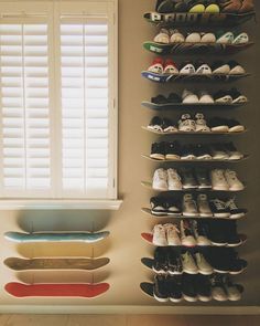 there is a skateboard on the wall next to some shelves with shoes in them