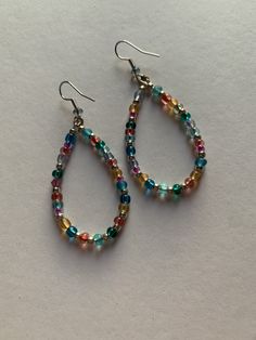 Assorted multicolor glass beads in these teardrop shape earrings. The wire is made of non-tarnish Silver. Adds a pop of color to any outfit. Handmade with love. Personalization available: can add more of a certain color, less, etc. Multicolor Wire Wrapped Drop Earrings, Multicolor Wire Wrapped Dangle Beaded Earrings, Multicolor Wire Wrapped Beaded Earrings, Multicolor Wire Wrapped Earrings With Round Beads, Multicolor Bohemian Teardrop Earrings With Ear Wire, Multicolor Teardrop Jewelry With Colorful Beads, Gift Teardrop Earrings With Colorful Beads, Colorful Beads Teardrop Earrings, Multicolor Wire-wrapped Beaded Earrings For Gift