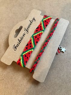 two red and green bracelets sitting on top of a cardboard box next to a star