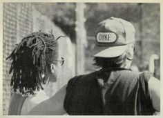 two people standing next to each other in front of a fence with the word oke on it