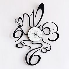 a black and white clock with swirly numbers in the shape of an abstract flower