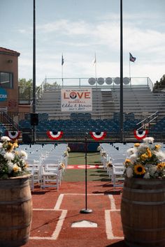 an empty baseball field with chairs and flowers