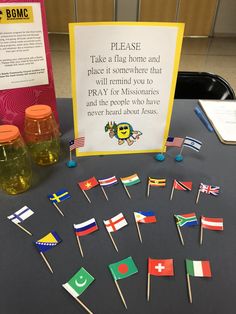 several small flags are placed on toothpicks next to a sign that says please take a flag home and place it somewhere