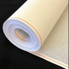 a roll of white and orange fabric on a black surface with an orange line in the middle