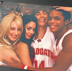 a group of young people standing next to each other in front of a photo frame