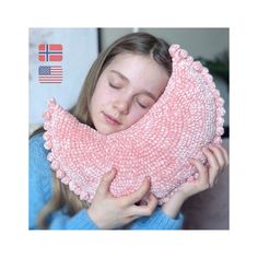 a girl is holding a pink pillow in front of her face and she has her eyes closed