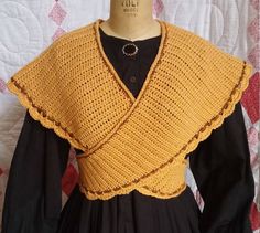 a woman's yellow shawl on top of a mannequin