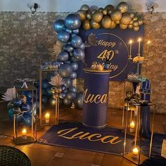 a blue and gold themed birthday party with balloons, candles and decorations on the floor