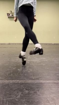 a person in black and white is skating on the ice with one foot up, while another leg down