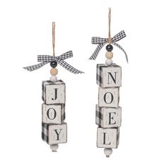 two wooden blocks with the words noely hanging from it's ends and tied to strings