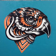 an eagle painted on the side of a blue wall with orange and white lines around it