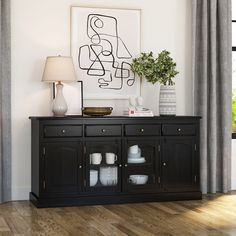 a black buffet table with two white vases and a painting on the wall behind it