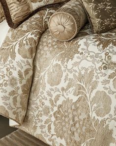 a bed covered in brown and white comforters