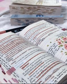 an open book sitting on top of a table next to other books and papers in front of it