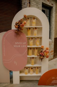 a display case filled with lots of yellow vases next to a sign that says spice up your life