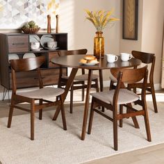 a dining room table with chairs and plates on it