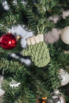 a close up of a christmas tree with ornaments hanging from it's branches and an ornament