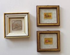 three framed pictures hang on the wall next to each other in gold and white frames