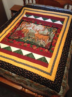 a bed with a quilt on top of it and a wooden headboard in the background