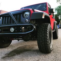 a red jeep is parked on the street