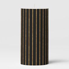 a black candle with gold stripes on it