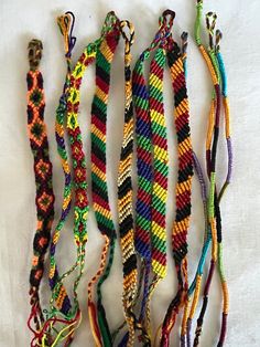 several colorful bracelets are arranged on a white surface