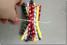 someone is stringing the ends of some colorful toothpicks with white and black dots