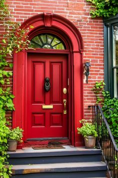 Red front door of a brick townhouse, adorned with greenery. Gray House With Red Door, Red Brick Colonial House Exterior, House Door Color Ideas, Brick Colonial House Exterior, Red Brick Colonial, Brick Colonial House, Front Door Color Ideas, Door Color Ideas, Entry Door Colors