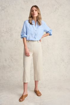 This 100% French linen shirt with natural shell buttons and elasticated cuffs is a light and breathable addition to any outfit. In addition to classic shirt details, it features intricate picot detailing along the pocket and hem. Available in Chambray Cross Dye, this shirt pairs perfectly with our signature Bengajean®. Spring Blouse With Button Cuffs And Relaxed Fit, Summer Beige Blouse With Button Cuffs, Beige Summer Blouse With Button Cuffs, Casual Beige Blouse With Button Cuffs, Flax Shirt With Buttons For Spring, Spring Flax Shirt With Buttons, Spring Shirt In Flax With Buttons, Beige Summer Tops With Button Cuffs, Spring Shirt With Button Cuffs For Casual Gatherings