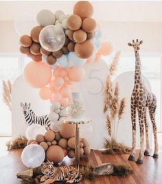 an animal themed birthday party with balloons and giraffes