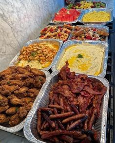 several trays filled with different types of food on top of a counter next to each other