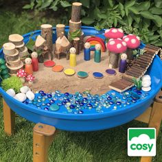 a sand table with toys in it on the grass