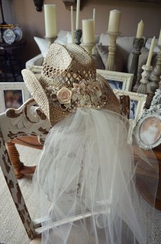 a chair with a hat on top of it in front of candles and other items