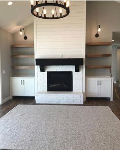 an empty living room with white brick fireplace