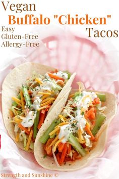 two chicken tacos are sitting on a pink plate with the title vegan buffalo chicken tacos