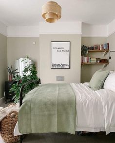 a bedroom with a bed, bookshelf and plants in the corner on the wall