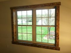 an empty room with a large window on the wall and grass in the back ground