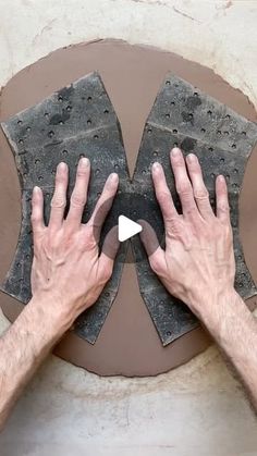 two hands on top of a piece of cement