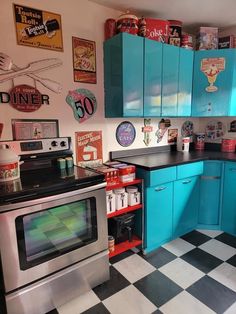 a kitchen with blue cabinets and black and white checkered flooring on the walls