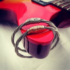 an electric guitar with two coils attached to it's neck and a red case